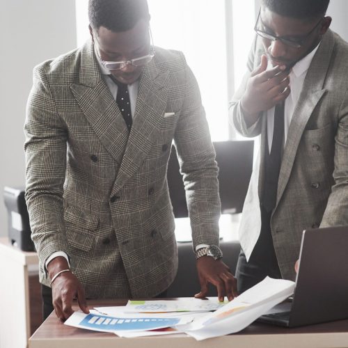 The image of two young African American businessmen who interact at a meeting in the office.